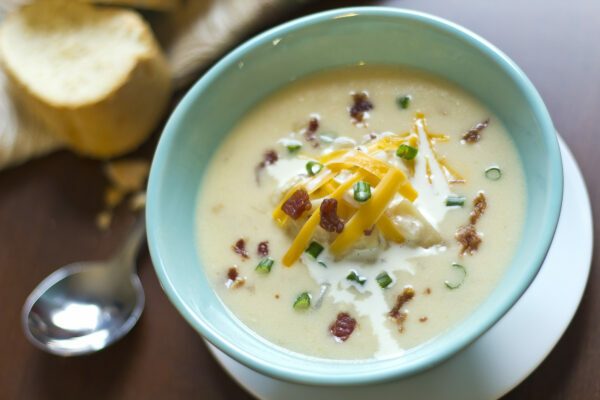 Creamy loaded slow cooked potato soup with bacon and fresh Italian bread